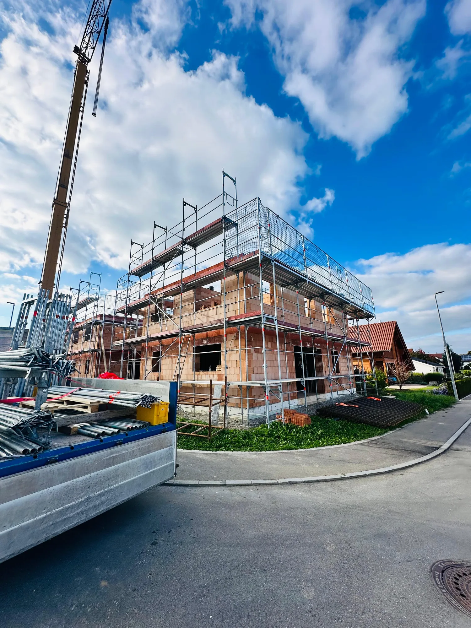 Gerüst an einem Neubau mit Baukran
